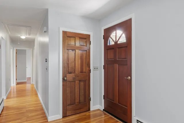 a view of a hallway with wooden floor and windows