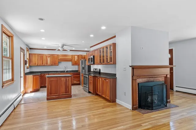 a view of kitchen with stainless steel appliances granite countertop cabinets and wooden floor