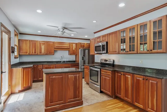 a kitchen with stainless steel appliances granite countertop wooden cabinets a sink and a stove