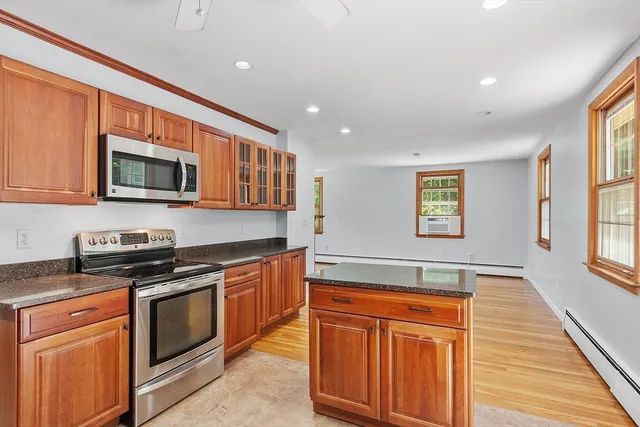 a kitchen with stainless steel appliances granite countertop a stove a sink and a microwave