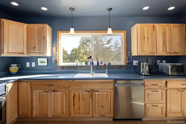 a kitchen with white cabinets and a window