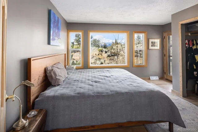 a large bed sitting in a bedroom next to a window