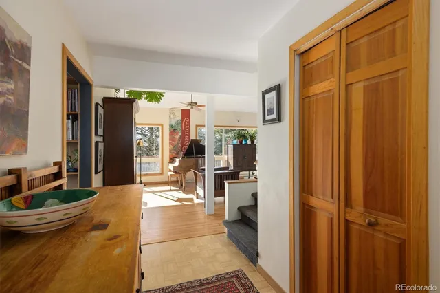 a living room with stainless steel appliances a refrigerator and furniture