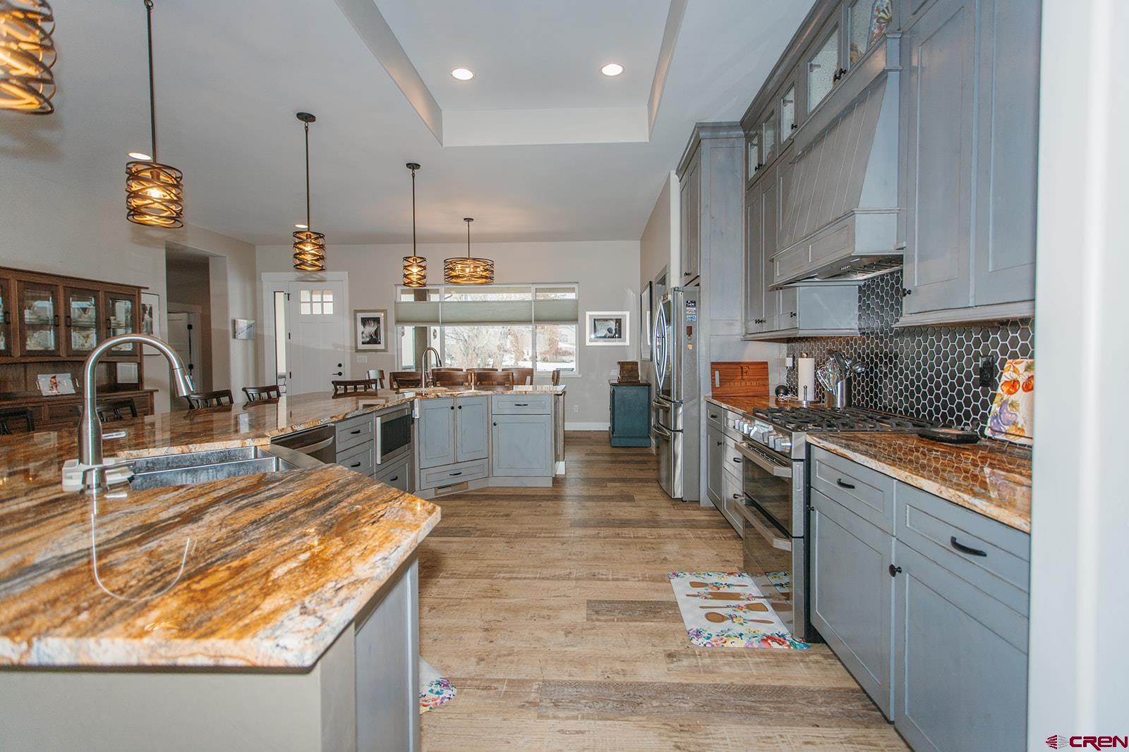4041 Pioneer Road Montrose, CO 81403 - Photo 12 of 43 a large kitchen with stainless steel appliances kitchen island granite countertop a sink and cabinets