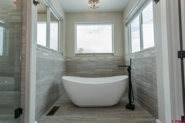 a white bath tub sitting in a bathroom next to a window