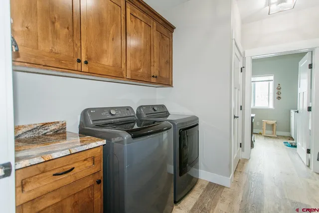 a view of a storage and utility room with wooden floor