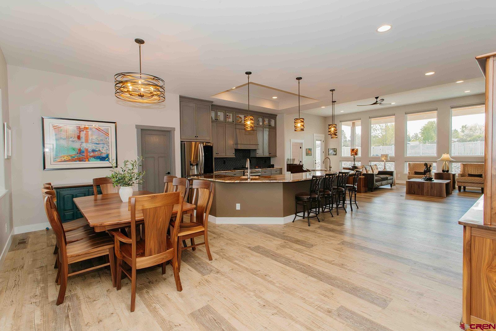 4041 Pioneer Road Montrose, CO 81403 - Photo 3 of 43 a view of a dining room and livingroom with furniture wooden floor a rug and a chandelier