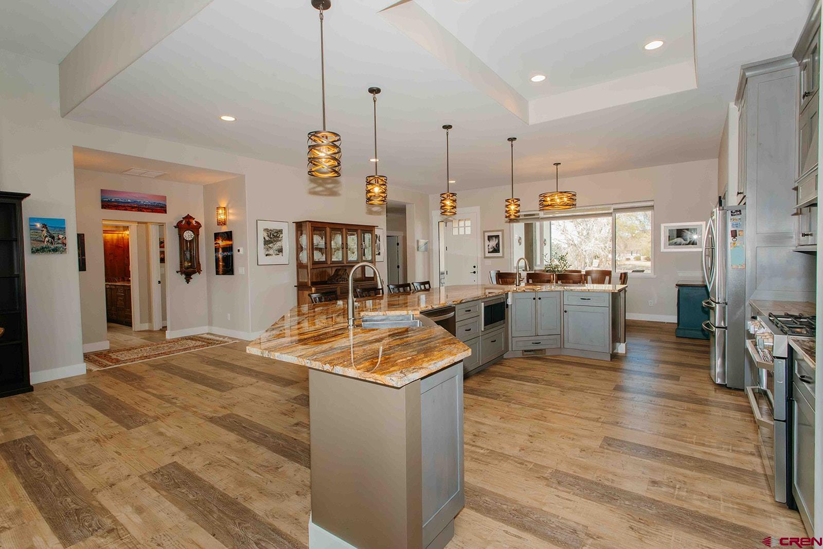 4041 Pioneer Road Montrose, CO 81403 - Photo 7 of 43 a open kitchen with stainless steel appliances granite countertop a sink dishwasher and a stove with wooden floor