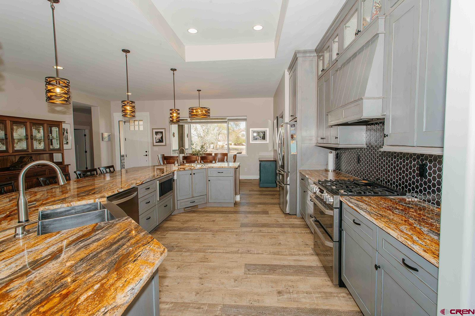 4041 Pioneer Road Montrose, CO 81403 - Photo 8 of 43 a kitchen with stainless steel appliances granite countertop a stove a sink and a refrigerator