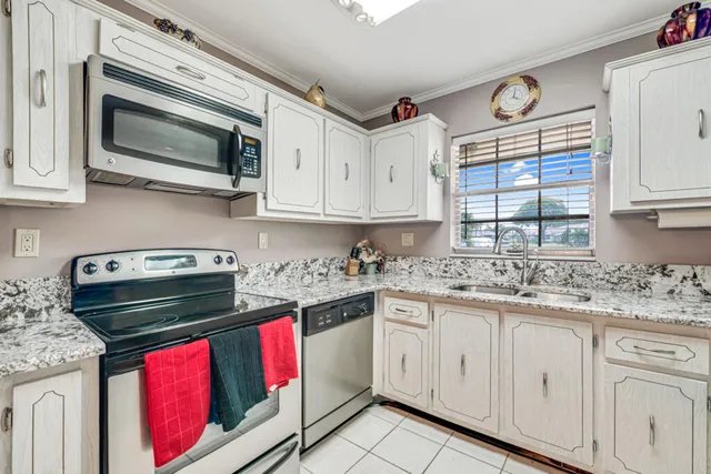 a kitchen with stainless steel appliances granite countertop a stove a sink and a microwave