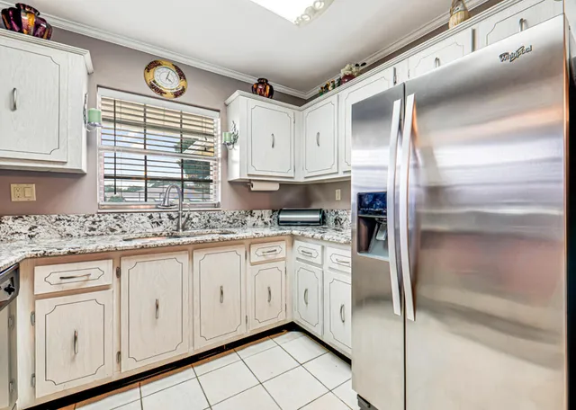 a kitchen with granite countertop white cabinets and white appliances