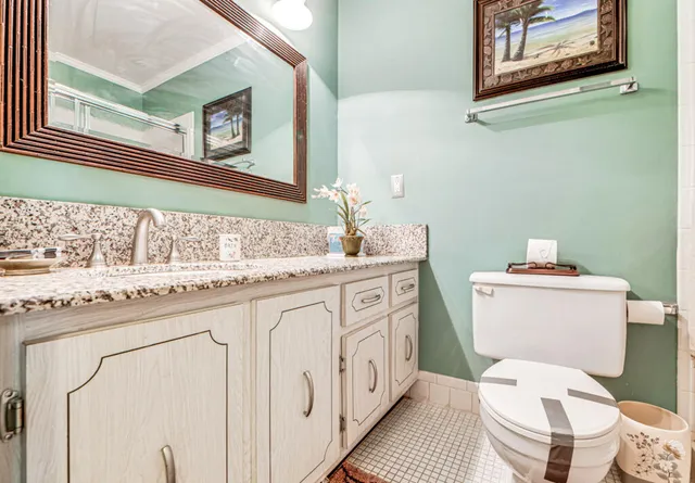 a bathroom with a granite countertop toilet sink and mirror