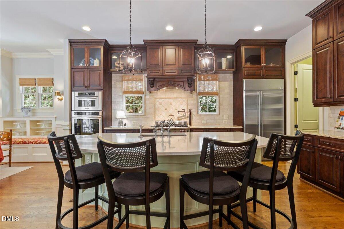 3916 Laurel Manor Court Raleigh, NC 27612 - Photo 13 of 53 a kitchen with stainless steel appliances granite countertop a kitchen island a table and chairs