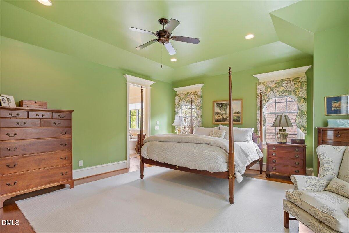 3916 Laurel Manor Court Raleigh, NC 27612 - Photo 23 of 53 a spacious bedroom with a bed and a chandelier