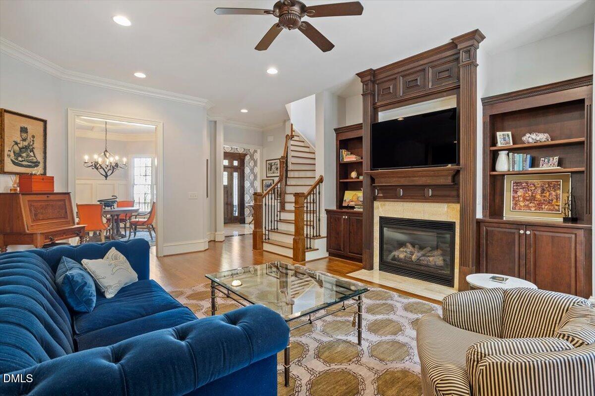 3916 Laurel Manor Court Raleigh, NC 27612 - Photo 9 of 53 a living room with furniture a flat screen tv and a fireplace