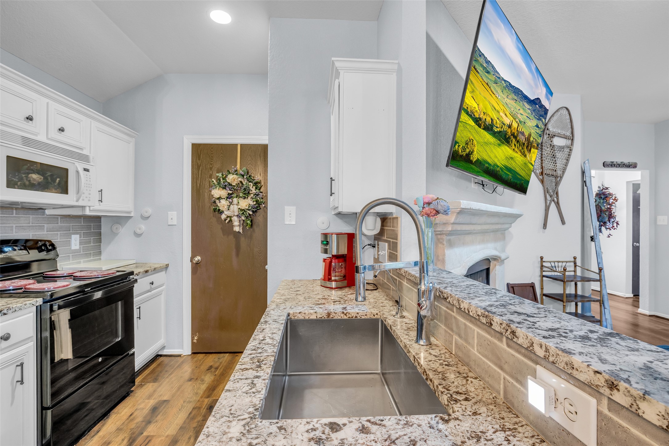 242 Sunset Path North Conroe, TX 77316 - Photo 22 of 37 Updated Galley kitchen features luxury granite selection, tile backsplash, deep sink and pull down faucet. 242 SUNSET PATH N - Request your tour today!