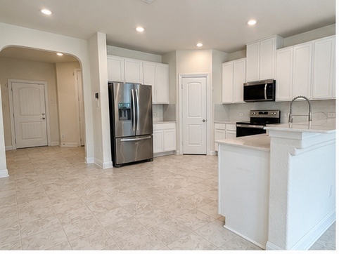 2101 Split Diamond Way, Unit 40 Round Rock, TX 78664 - Photo 2 of 32 A well-appointed culinary space featuring sleek stainless-steel appliances and pristine white cabinetry.