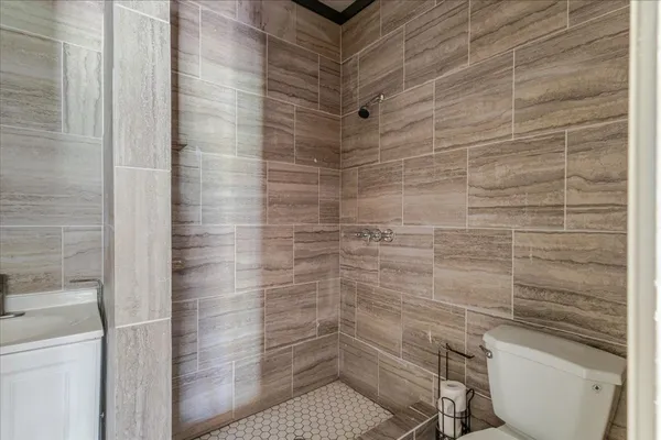 a bathroom with a toilet and a shower