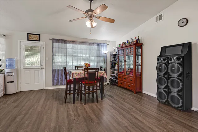 a kitchen with stainless steel appliances kitchen island granite countertop a table chairs in it and a window