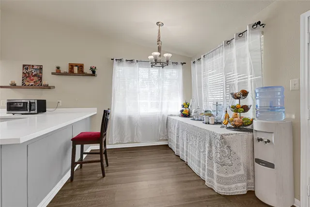 a kitchen with a table chairs refrigerator and a wooden cabinets