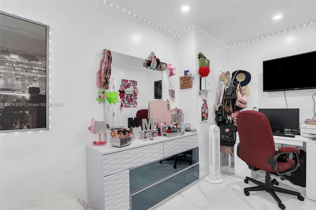 a view of a workspace with furniture and a flat screen tv