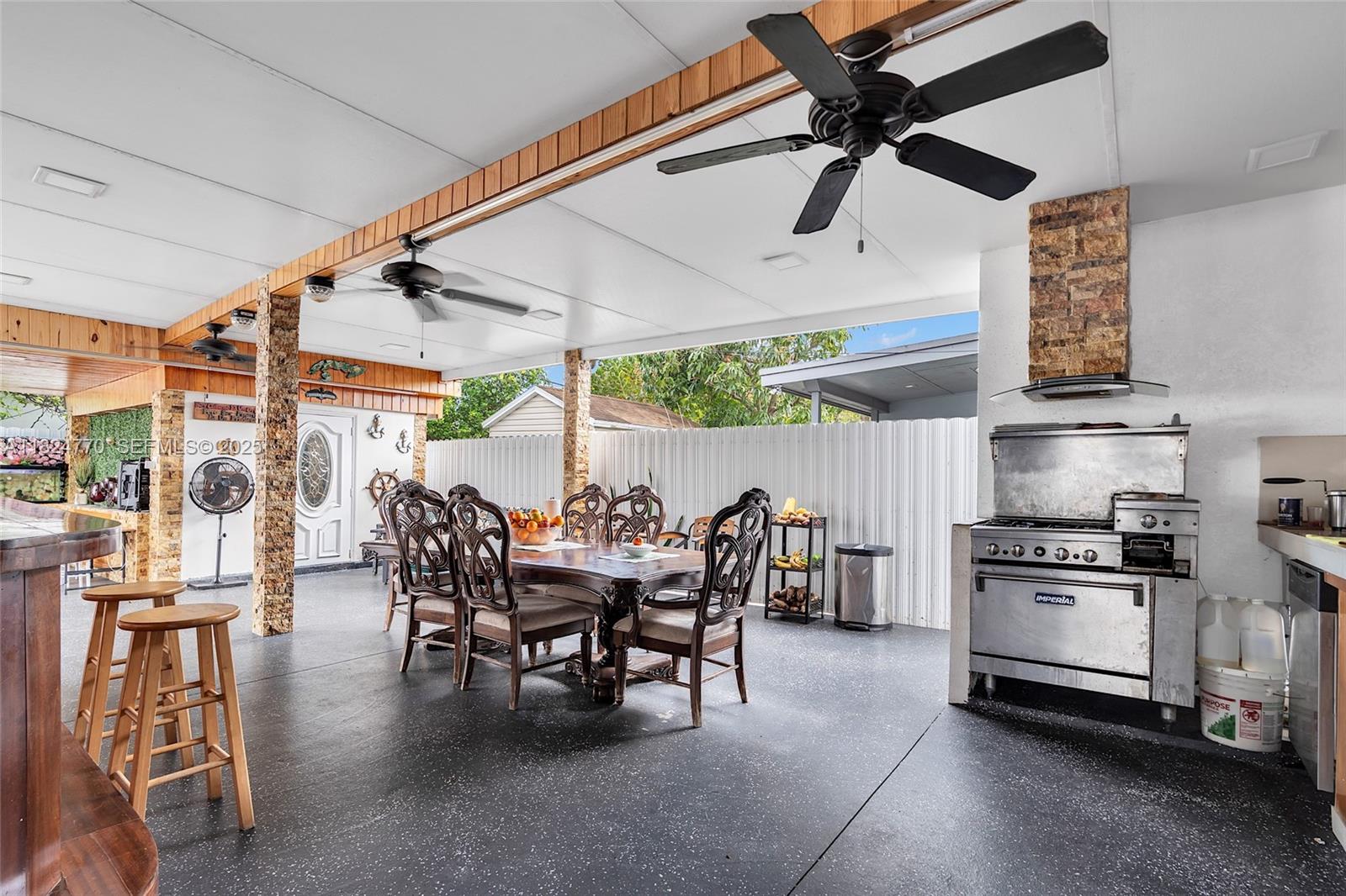 31 Southwest 58th Court Miami, FL 33144 - Photo 40 of 41 a kitchen with stainless steel appliances kitchen island granite countertop a table and chairs in it