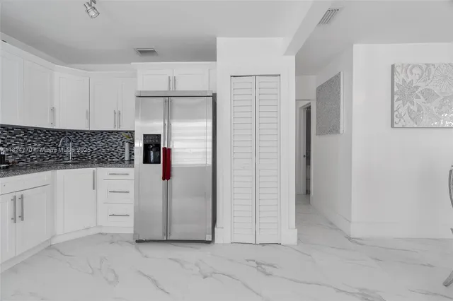 a kitchen with white cabinets and white appliances