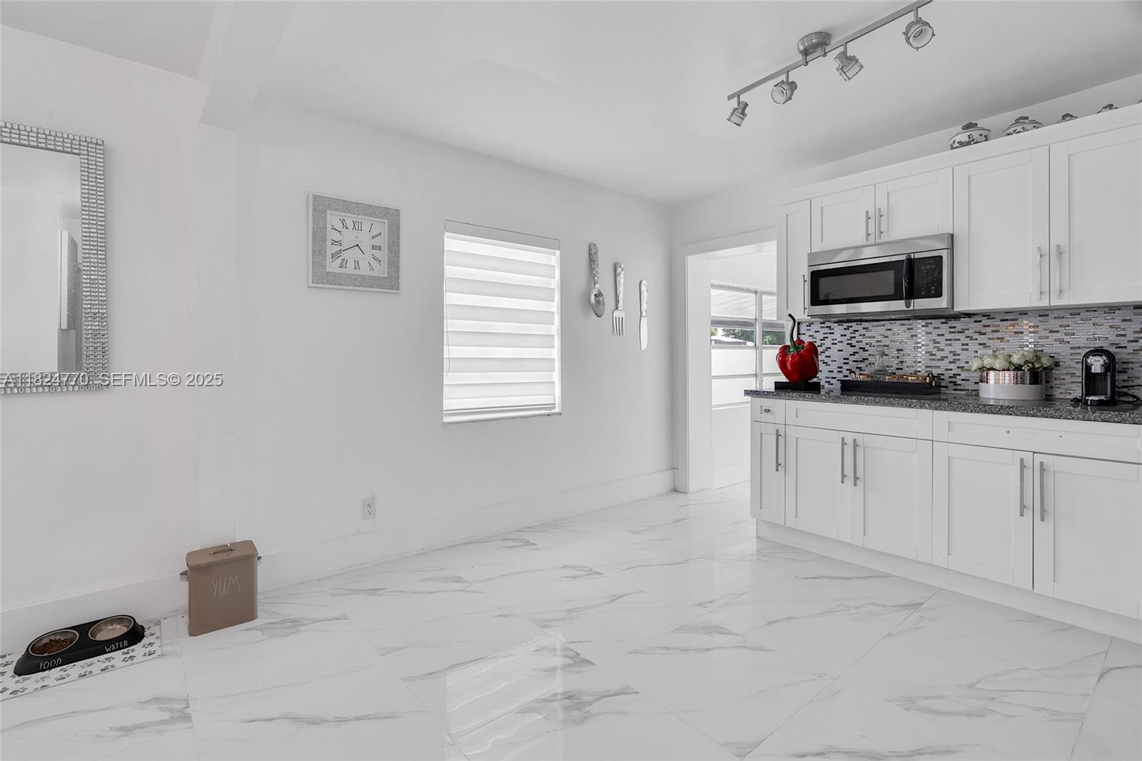 31 Southwest 58th Court Miami, FL 33144 - Photo 10 of 41 a kitchen with white cabinets and window