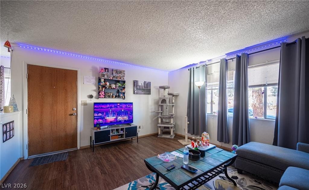 855 Del Rey Drive Boulder City, NV 89005 - Photo 11 of 12 Rich wood flooring grounds this living space, offering views through large windows.