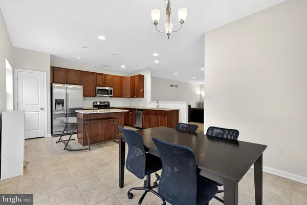 a view of kitchen with cabinets stainless steel appliances and a dining table