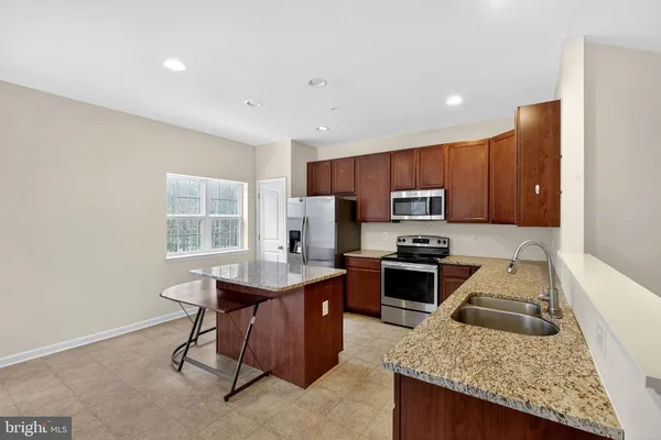 a kitchen with wooden cabinets and stainless steel appliances
