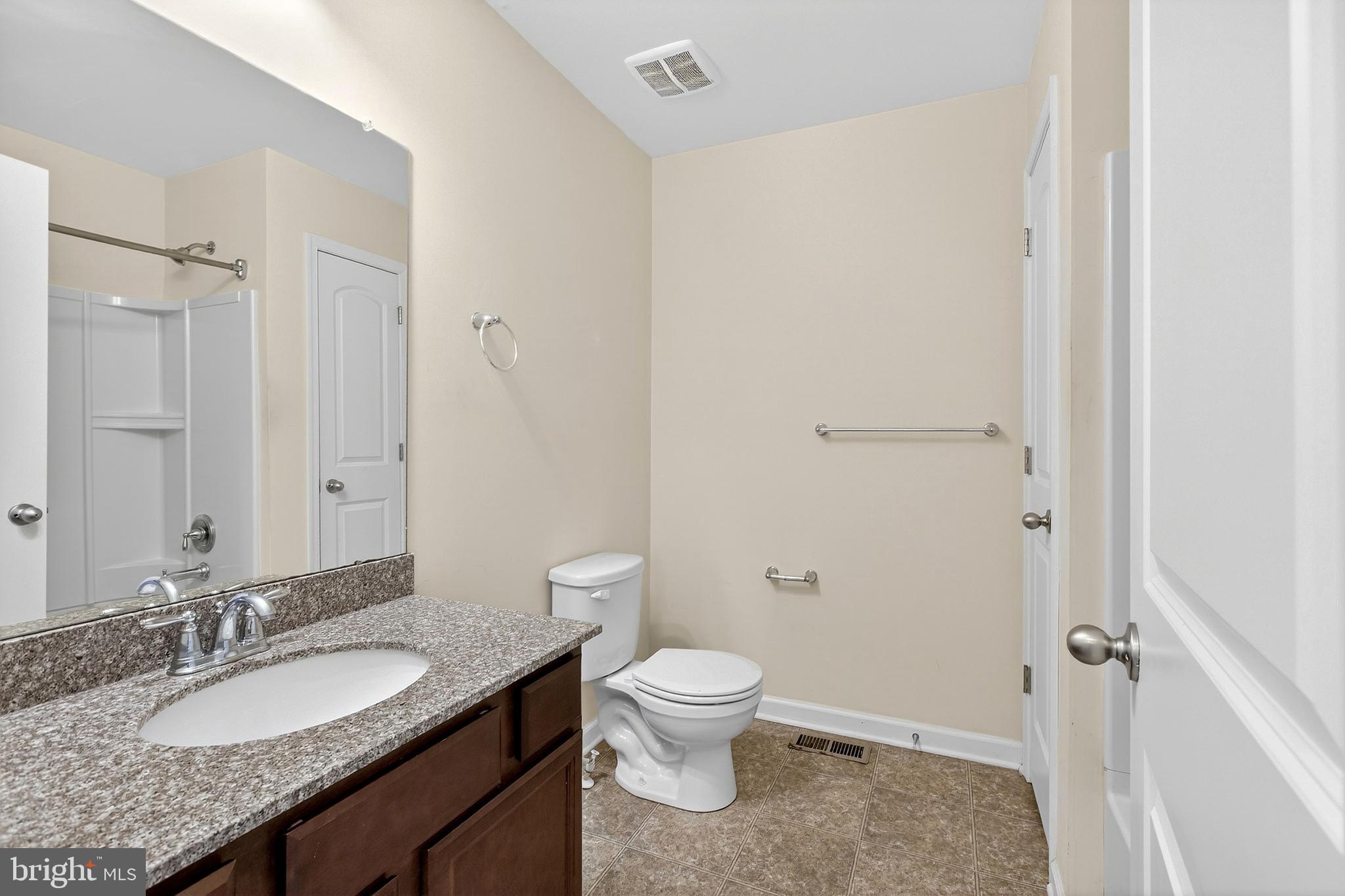 48 Munro Road Newark, DE 19711 - Photo 36 of 50 a bathroom with a granite countertop sink a toilet and a mirror