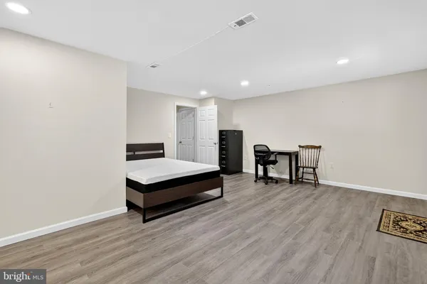 a spacious bedroom with a bed and a flat screen tv