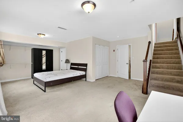 a view of an empty room with stairs and furniture