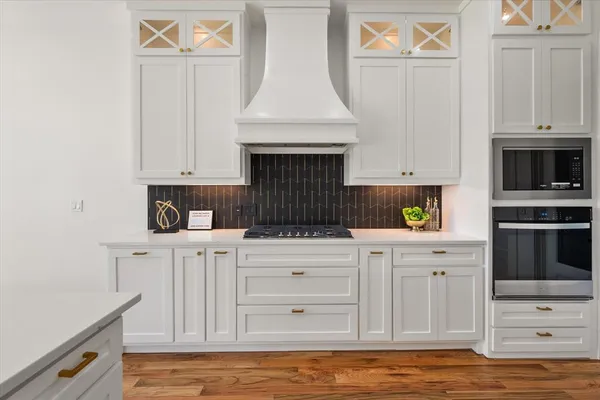 a kitchen with stainless steel appliances a stove and white cabinets