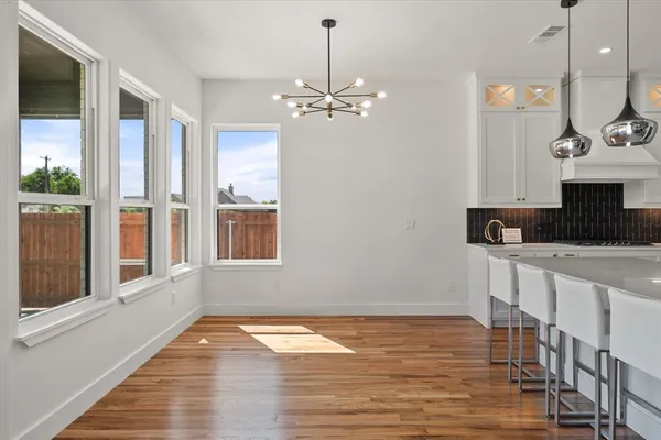 a view of a kitchen with wooden floor and a window