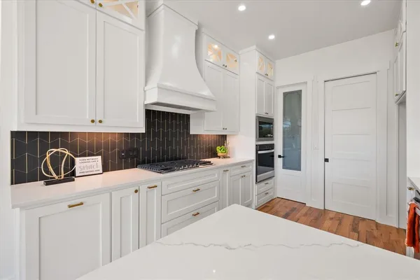 a kitchen with stainless steel appliances a sink a stove a refrigerator and cabinets