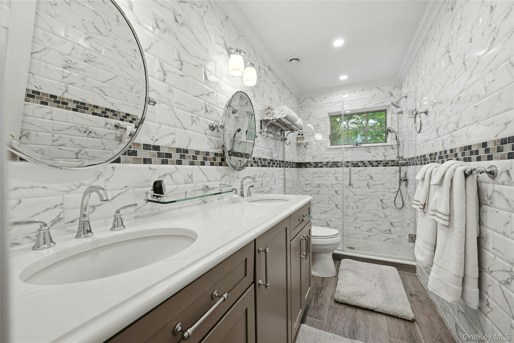6 Thunder Road Miller Place, NY 11764 - Photo 31 of 50 The Magnificent New $40,000 Guest Bathroom Is Completely Wrapped In Floor To Ceiling Stunning Subway Tiled Walls With Accent Borders/Trims, An Oversized Custom Shower With Frameless Glass Doors, Dual Sink Quartz Topped Vanity, Custom Moldings, Recessed Lighting, Porcelain Plank Tiled Floors & All High End Fixtures.