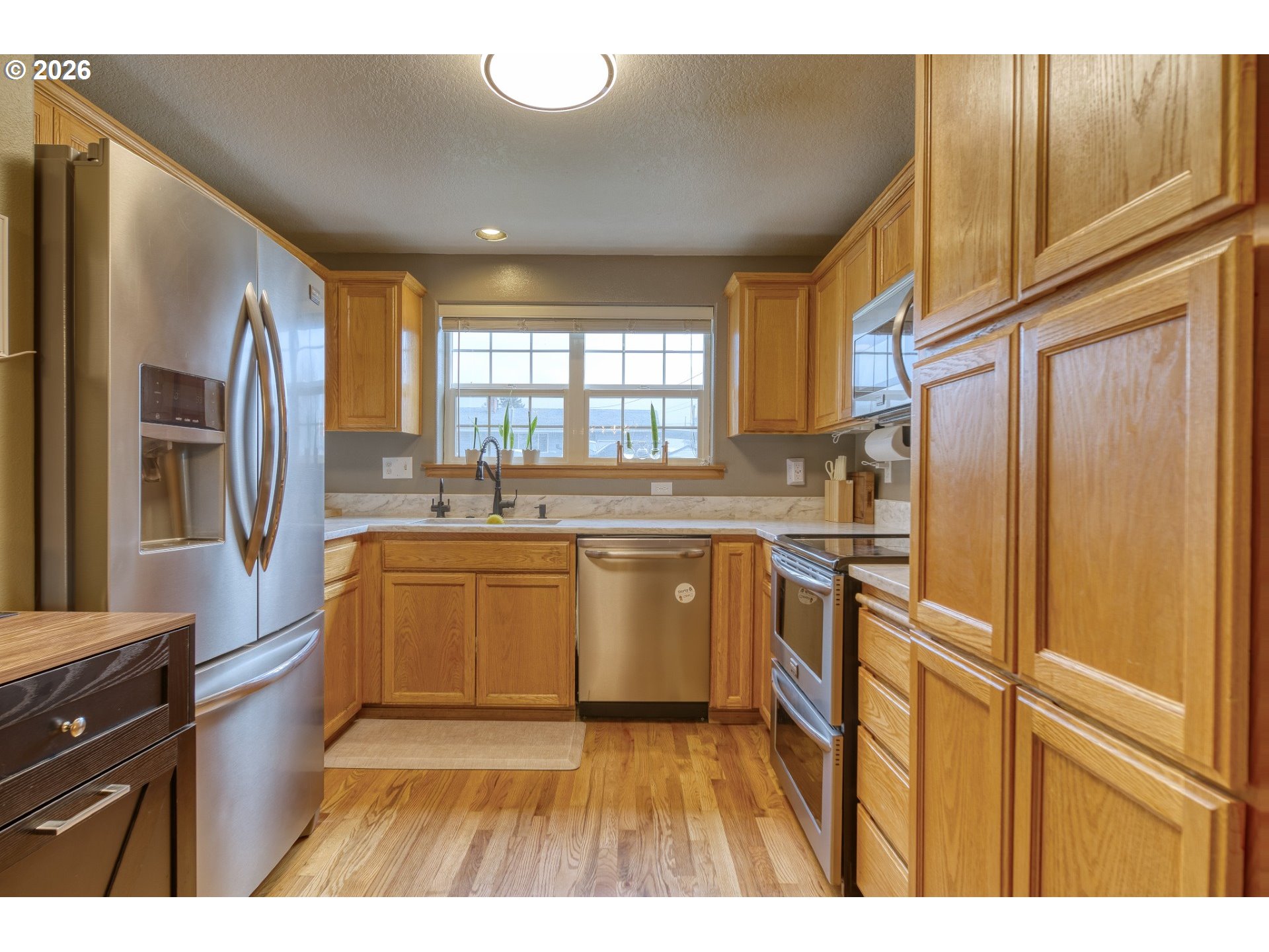 435 South 8th Street St. Helens, OR 97051 - Photo 8 of 39 a kitchen with stainless steel appliances granite countertop a refrigerator a sink dishwasher and wooden cabinets