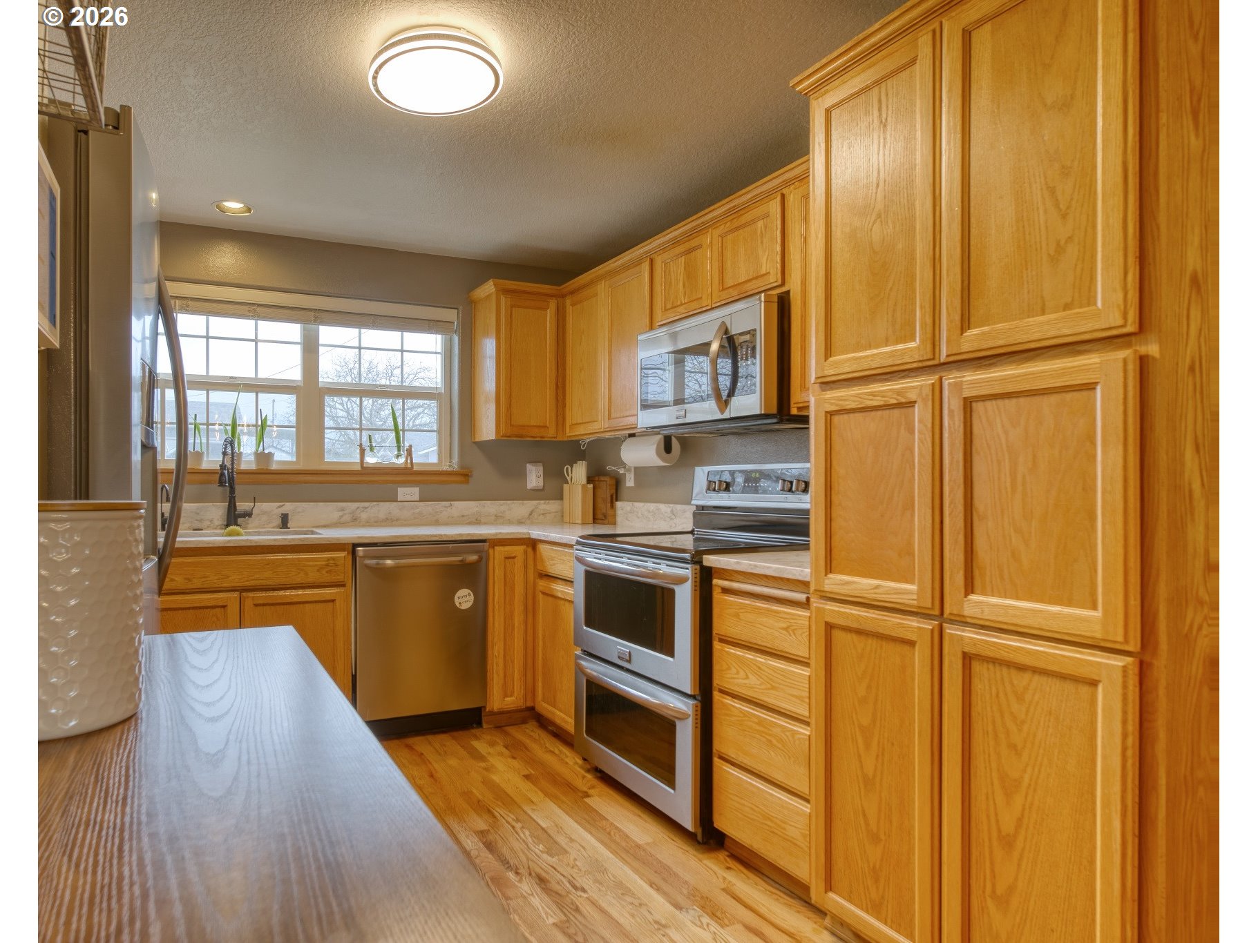 435 South 8th Street St. Helens, OR 97051 - Photo 9 of 39 a kitchen with stainless steel appliances granite countertop white cabinets and window