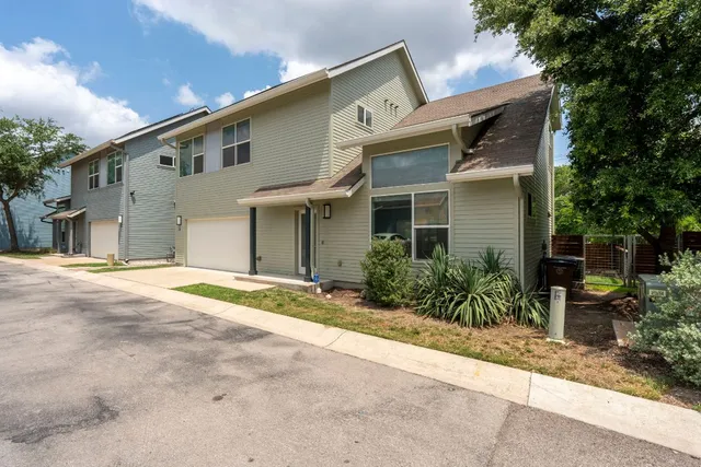 a view of a white house with a large windows and plants