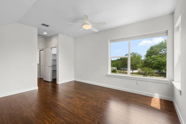 a view of a hallway with wooden floor and entryway