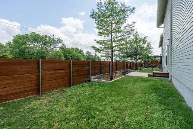 a view of a backyard with wooden fence