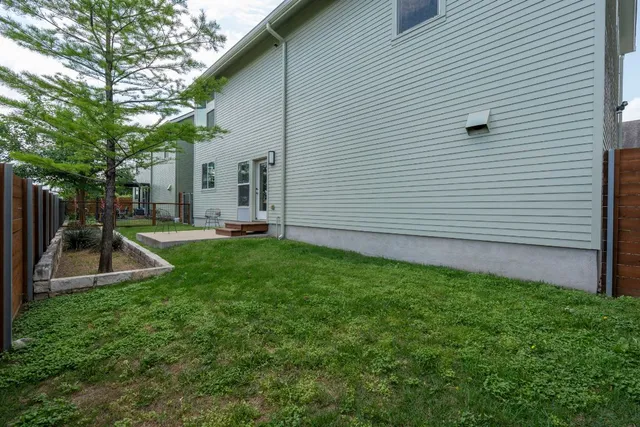 a view of a house with backyard and a tree