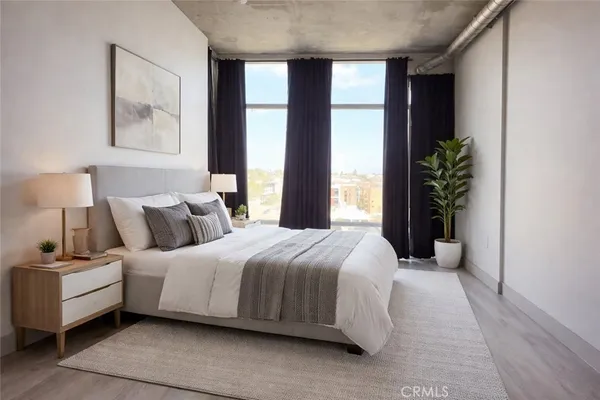 a bedroom with a large bed and a potted plant