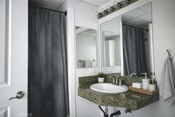 a bathroom with a granite countertop sink and a mirror