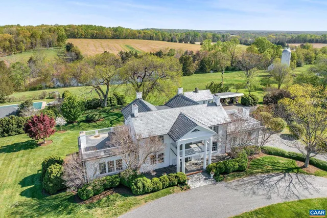 an aerial view of a house with a garden and lake view