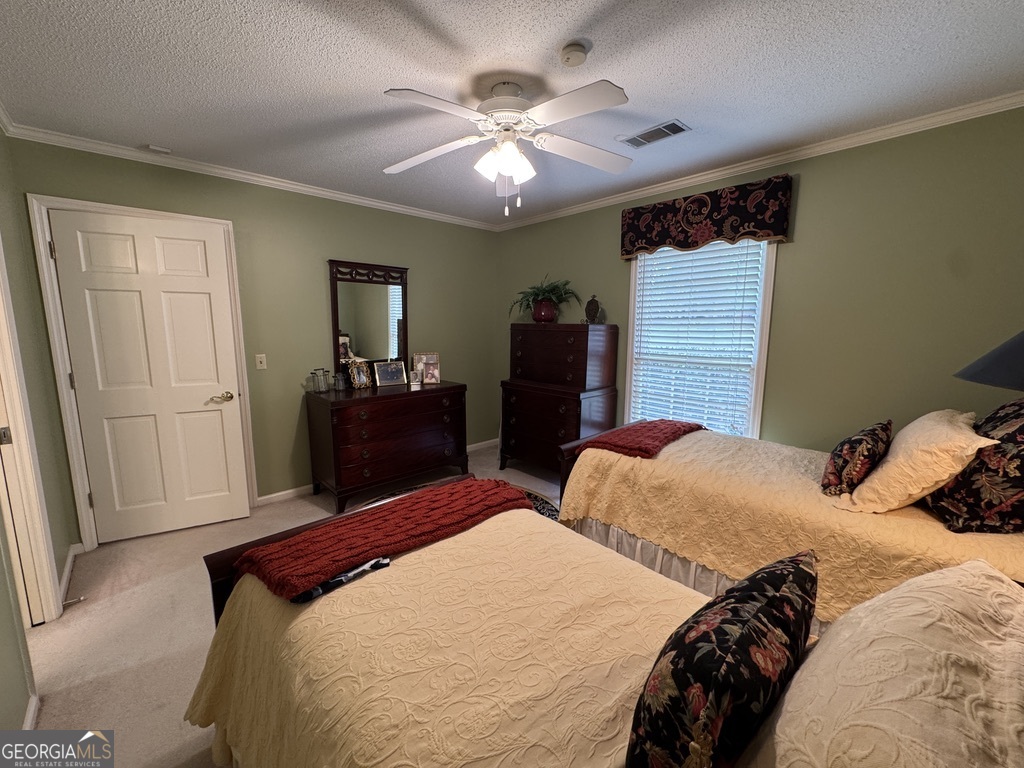410 Preston Street Metter, GA 30439 - Photo 35 of 39 a bedroom with two beds and a chandelier