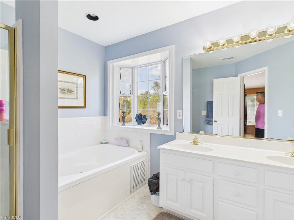 4212 Suffolk Trail Greensboro, NC 27407 - Photo 30 of 40 Primary bathroom with tub looking back out to the natural area.