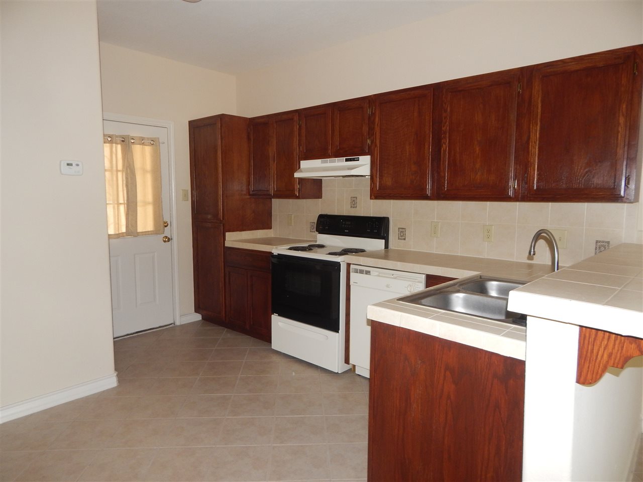 1602 Jacaman Road, Unit 4 Laredo, TX 78041 - Photo 5 of 9 a kitchen with stainless steel appliances granite countertop a stove a sink dishwasher and a refrigerator with wooden cabinets